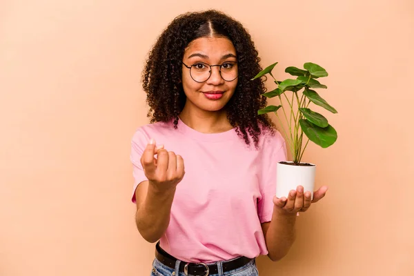 Young African American Woman Holding Plant Isolated Beige Background Pointing — 스톡 사진