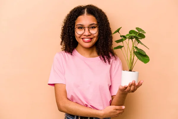 Young African American Woman Holding Plant Isolated Beige Background Laughing — 스톡 사진