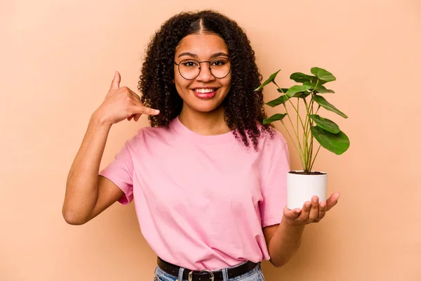 Young African American Woman Holding Plant Isolated Beige Background Showing — 스톡 사진