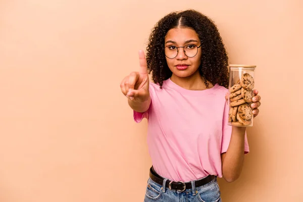 Young African American Woman Holding Cookies Jar Isolated Beige Background — Stok fotoğraf