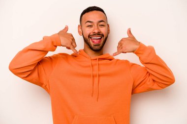 Beyaz arka planda izole edilmiş genç bir İspanyol, parmakları olan bir cep telefonu hareketi gösteriyor..