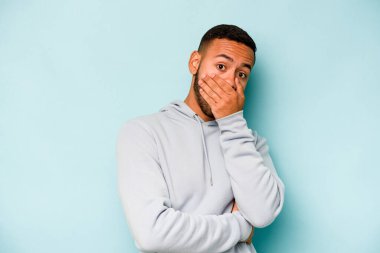 Genç İspanyol adam mavi arka planda izole edilmiş korkmuş ve korkmuş..