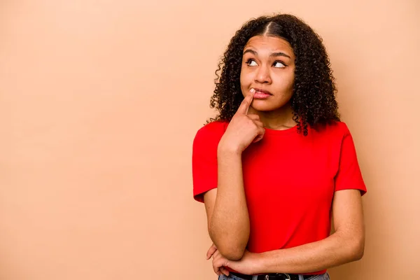 Ung Afrikansk Amerikansk Kvinna Isolerad Beige Bakgrund Tittar Sidledes Med — Stockfoto