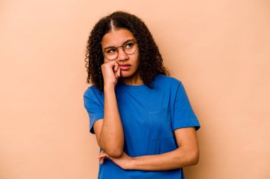 Genç Afrikalı Amerikalı kadın bej arka planda izole edilmiş. Tekrarlanan bir görevden yorulmuş..