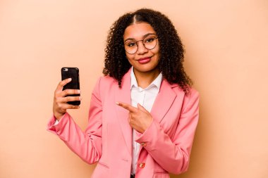 Bej arka planda cep telefonu tutan genç Afrikalı Amerikalı iş kadını