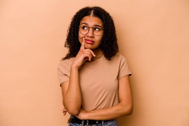 Genç Afrikalı Amerikalı kadın bej arka planda izole edilmiş bir şekilde bir strateji planlıyor, bir iş hayatının nasıl olacağını düşünüyor..