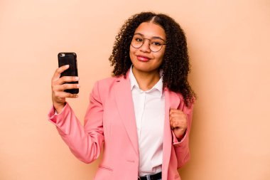 Bej arka planda cep telefonu tutan genç Afrikalı Amerikalı iş kadını