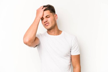 Beyaz arka planda izole edilmiş genç beyaz bir adam bir şeyi unutuyor. Alnına avuç içi ve gözlerini kapayarak vuruyor..