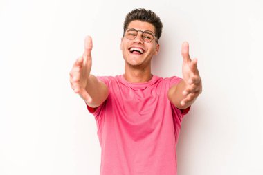 Beyaz arka planda izole edilmiş genç beyaz adam kameraya sarıldığı için kendinden emin hissediyor..
