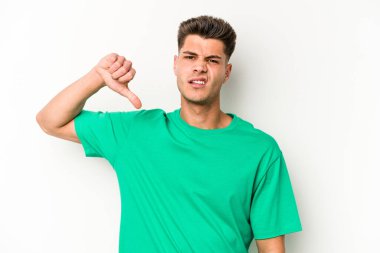 Beyaz arka planda izole edilmiş genç beyaz adam baş parmağını aşağı gösteriyor, hayal kırıklığı konsepti..