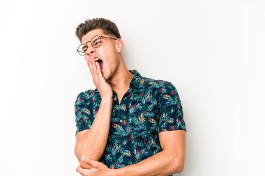 Beyaz arka planda izole edilmiş genç beyaz adam esniyor. Ağzı eliyle kapatan yorgun bir hareket sergiliyor..