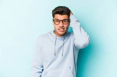 Mavi arka planda izole genç beyaz adam şok oldu, o önemli bir toplantı hatırladı.