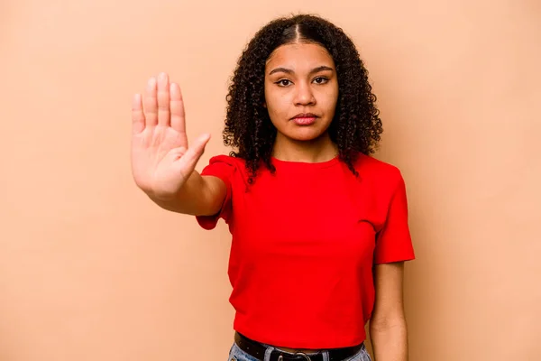 Mujer Afroamericana Joven Aislada Sobre Fondo Beige Pie Con Mano —  Fotos de Stock