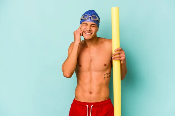 Young Caucasian Swimmer Man Holding Foam Stick Isolated Blue Background — Foto Stock