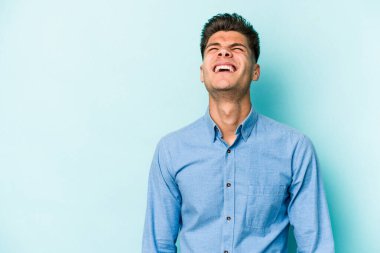 Kafkasyalı genç adam mavi arka planda izole edilmiş. Çok kızgın, öfkeli, hayal kırıklığına uğramış..