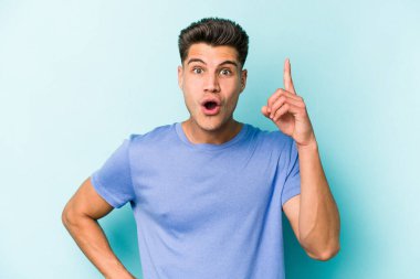 Kafkasyalı genç bir adam mavi arka planda izole edilmiş. Bir fikri, ilham verici bir fikri var..