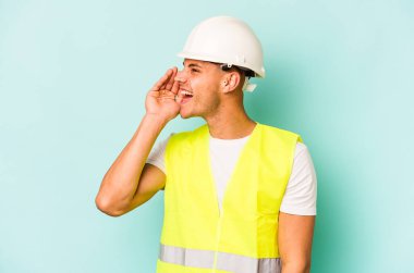 Beyaz tenli genç işçi mavi arka planda izole edilmiş bağırıyor ve avuç içini açık tutuyordu..