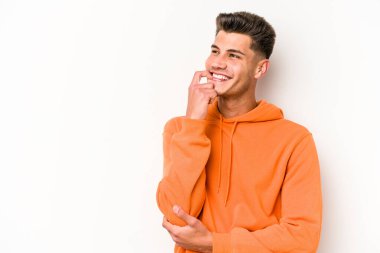 Beyaz arka planda izole edilmiş genç beyaz bir adam rahatlamış bir şeyin fotokopi odasına baktığını düşünüyor..