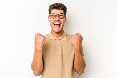 Beyaz arka planda izole edilmiş genç beyaz adam tasasız ve heyecanlı bir şekilde tezahürat yapıyor. Zafer konsepti.