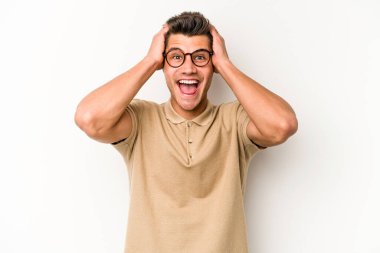 Beyaz arka planda izole olmuş genç beyaz bir adam çığlık atıyor, çok heyecanlı, tutkulu, bir şeyden memnun..