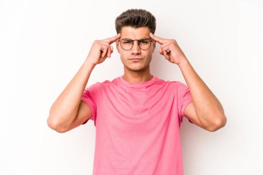 Beyaz arka planda izole edilmiş genç beyaz bir adam bir göreve odaklanmış, işaret parmaklarını işaret ediyor..