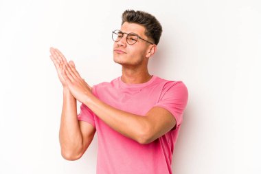 Beyaz arka planda izole olmuş genç beyaz bir adam enerjik ve rahat hissediyor, ellerini ovuşturuyor..