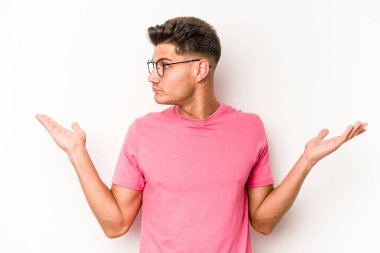 Beyaz arka planda izole edilmiş genç beyaz bir adam. Kafası karışmış ve omuz silkiyor. Kopya alanını tutmak için..