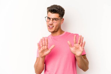 Beyaz arka planda izole edilmiş genç beyaz bir adam tiksinti belirtisi gösteren birini reddediyor..