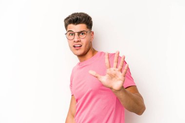 Beyaz arka planda izole genç beyaz adam yakın bir tehlike nedeniyle şoka uğruyor