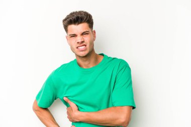 Beyaz arka planda karaciğer ağrısı çeken, karnı ağrıyan genç beyaz bir adam..