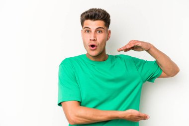 Beyaz arka planda izole edilmiş beyaz bir adam iki eliyle bir şey tutuyor..