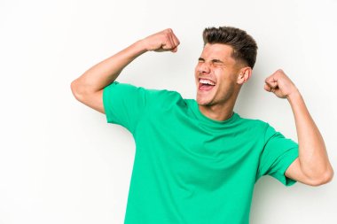 Beyaz arka planda izole edilmiş genç beyaz bir adam zaferden sonra yumruğunu kaldırıyor, kazanan konsept.