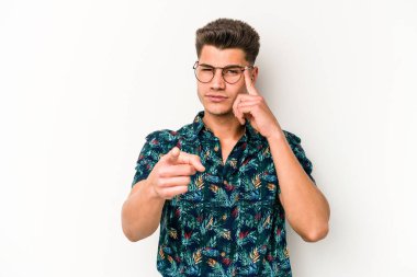 Beyaz arka planda izole edilmiş genç beyaz bir adam şakağı parmağıyla işaret ediyor, düşünüyor ve bir göreve odaklanıyor..