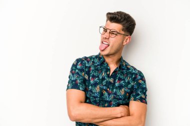 Beyaz arka planda izole edilmiş genç beyaz bir adam. Komik ve dost canlısı bir dil uzatıyor..