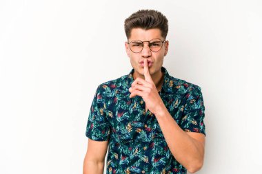 Beyaz arka planda izole edilmiş genç beyaz bir adam ya sır saklıyor ya da sessizlik istiyor..