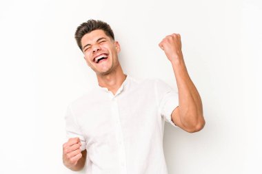 Beyaz arka planda izole edilmiş genç beyaz adam tasasız ve heyecanlı bir şekilde tezahürat yapıyor. Zafer konsepti.