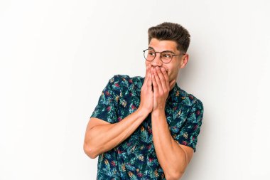 Beyaz arka planda izole olmuş genç beyaz bir adam bir şeye gülüyor, ağızlarını ellerle kapatıyor..