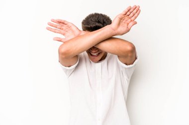 Beyaz arka planda izole genç beyaz adam iki kolu çapraz tutuyor, inkar kavramı.