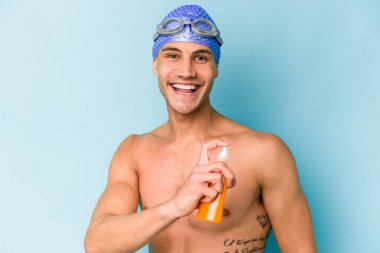 Sakallı ve havlusu olan genç yakışıklı adam izole edilmiş arka planda gülümsüyor ve yan tarafa bakıyor.