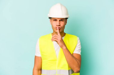 Genç beyaz adam mavi arka planda izole edilmiş bir şekilde bir sır saklıyor ya da sessizlik istiyor..