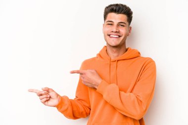 Beyaz arka planda izole edilmiş genç beyaz bir adam işaret parmağıyla işaret ettiği için heyecanlı..