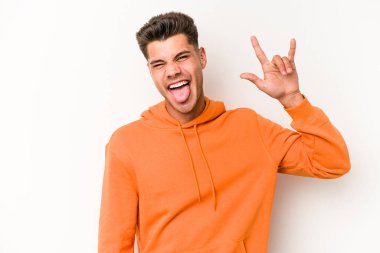 Beyaz arka planda izole edilmiş genç beyaz bir adam boynuzlarını devrim konsepti olarak gösteriyor..