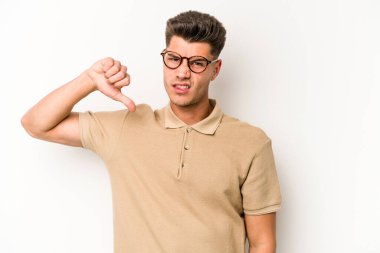 Beyaz arka planda izole edilmiş genç beyaz adam baş parmağını aşağı gösteriyor, hayal kırıklığı konsepti..