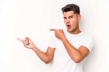 Beyaz arka planda izole edilmiş genç beyaz bir adam işaret parmağıyla fotokopi alanını işaret ederek heyecan ve arzusunu ifade ediyor..