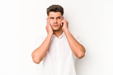Beyaz arka planda izole edilmiş genç beyaz bir adam parmaklarıyla kulaklarını kapatıyor, gürültülü bir ortam yüzünden stresli ve çaresiz..