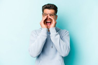 Mavi arka planda izole edilmiş beyaz bir adam heyecanlı bir şekilde bağırıyor..