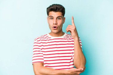 Kafkasyalı genç adam mavi arka planda izole edildi. Harika bir fikri var, yaratıcılık kavramı..