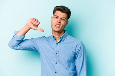 Mavi arka planda izole edilmiş genç beyaz bir adam hoşlanmadığı bir jest yapıyor. Anlaşmazlık konsepti.