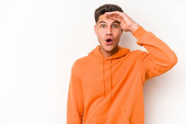 Beyaz arka planda izole genç beyaz adam yüksek sesle bağırıyor, gözleri açık ve elleri gergin tutuyor..