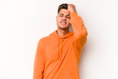 Beyaz arka planda izole edilmiş genç beyaz bir adam bir şeyi unutuyor. Alnına avuç içi ve gözlerini kapayarak vuruyor..